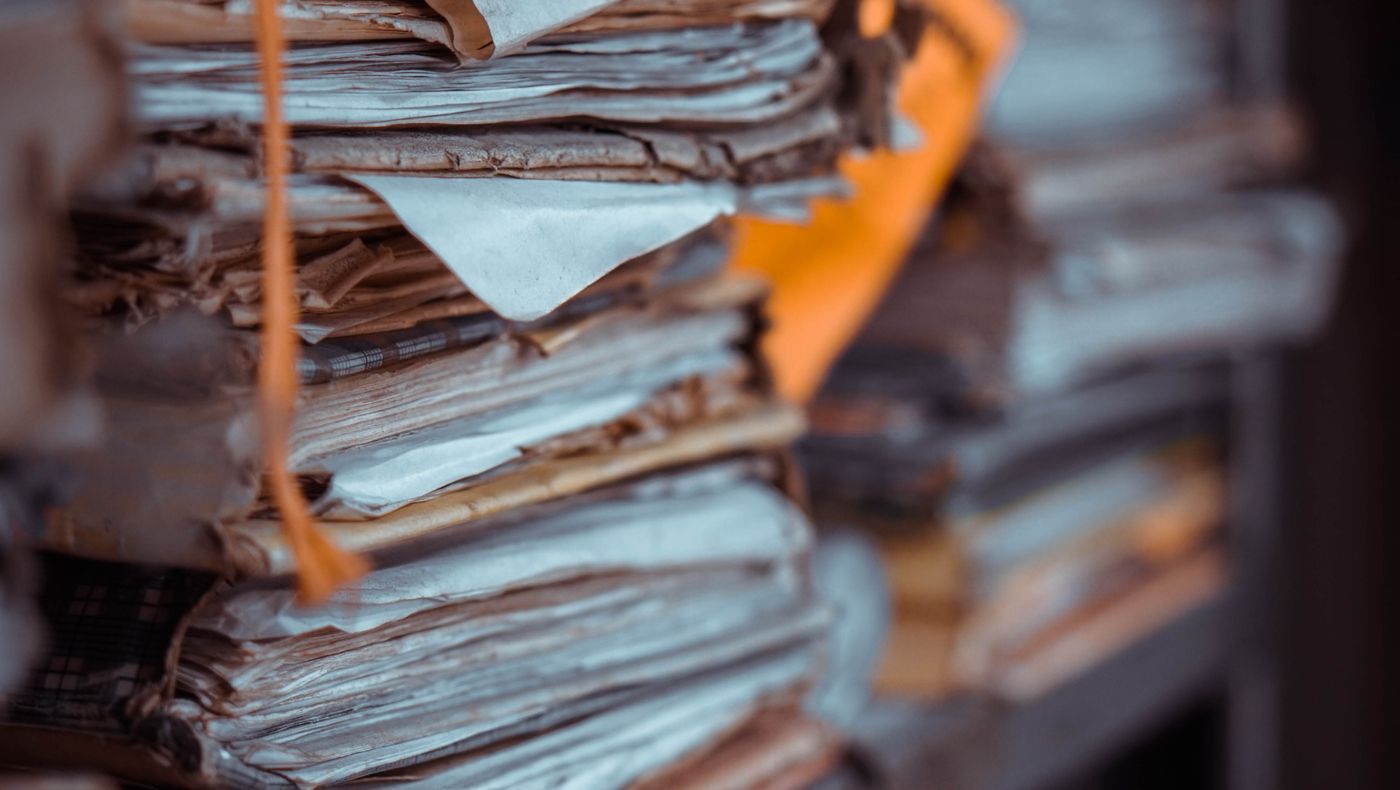 Stacks of paper files and folders on a shelf