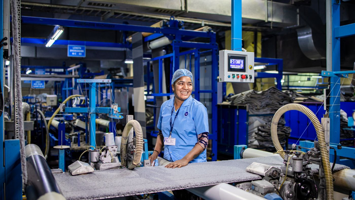 Two workers at a control station on a factory floor